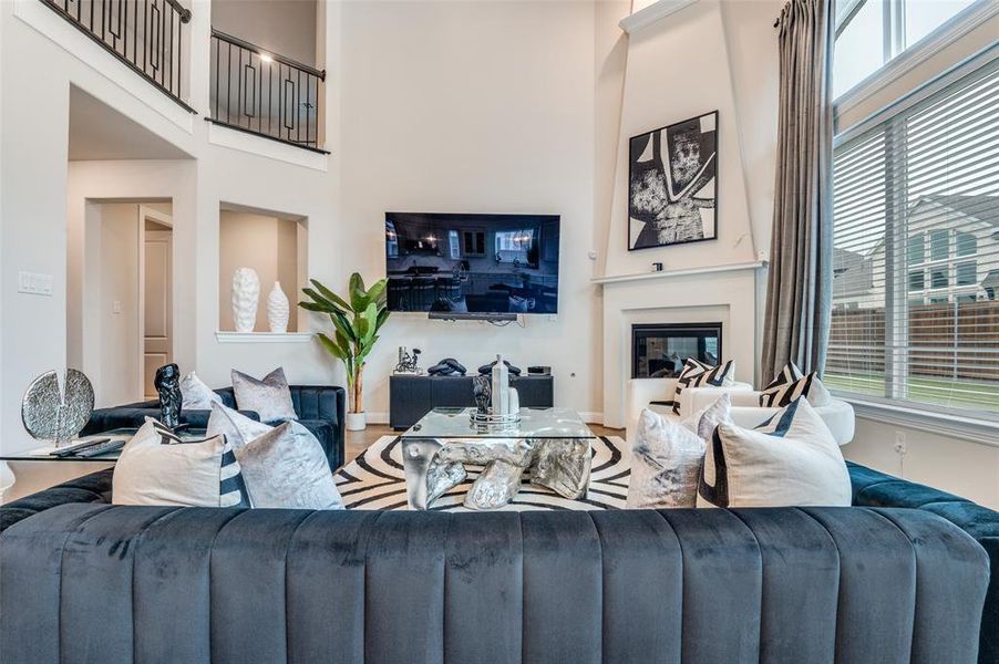 Living area with a high ceiling and a glass covered fireplace