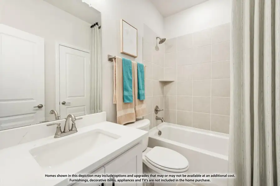 Bathroom with white vanity, tiled shower-tub combo, and large mirror