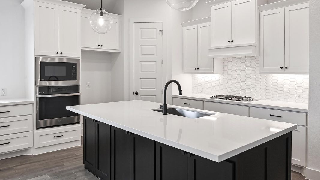 Kitchen with appliances with stainless steel finishes, a sink, white cabinets, and backsplash Kitchen with appliances with stainless steel finishes, a sink, white cabinets, and backsplash