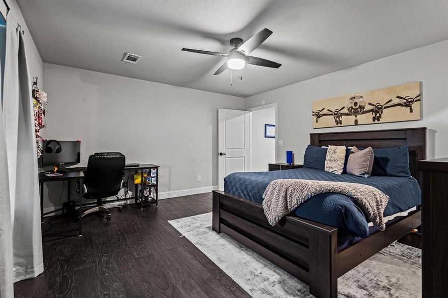 Bedroom featuring dark wood finished floors, an office area, and ceiling fan Bedroom featuring dark wood finished floors, an office area, and ceiling fan