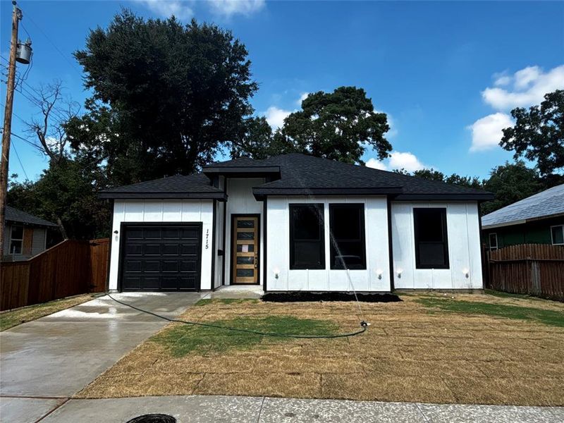 View of front of home with a garage and a front yard