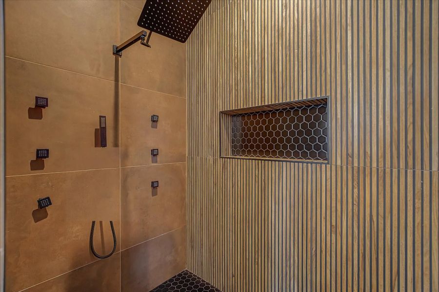 Spacious walk-in shower featuring a custom-built recessed niche for convenient storage of shower essentials.