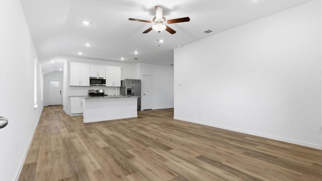 A well-organized living room that includes a kitchen and dining area, creating a warm and welcoming environment for gatherings.