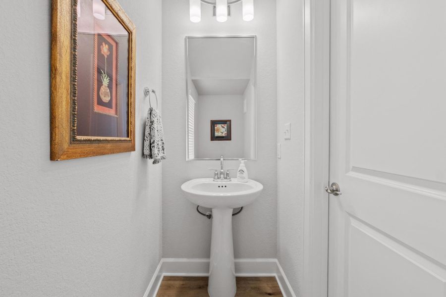 Bathroom featuring baseboards and wood finished floors Bathroom featuring baseboards and wood finished floors