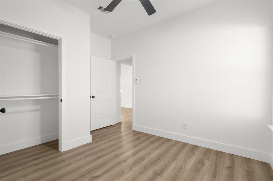 Unfurnished bedroom featuring a closet, light hardwood / wood-style floors, and ceiling fan