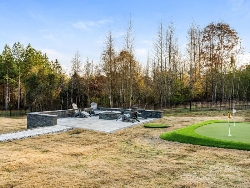 Custom designed paver patio w/gas fire pit surrounded by sitting wall and putting green