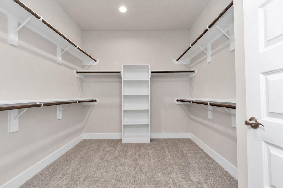 walk-in closet that epitomizes luxury and practicality. This generously sized space features built-in shelving, offering abundant room for impeccable organization. Sample photo of completed home with similar floor plan. Actual colors and selections may vary. walk-in closet that epitomizes luxury and practicality. This generously sized space features built-in shelving, offering abundant room for impeccable organization. Sample photo of completed home with similar floor plan. Actual colors and selections may vary.