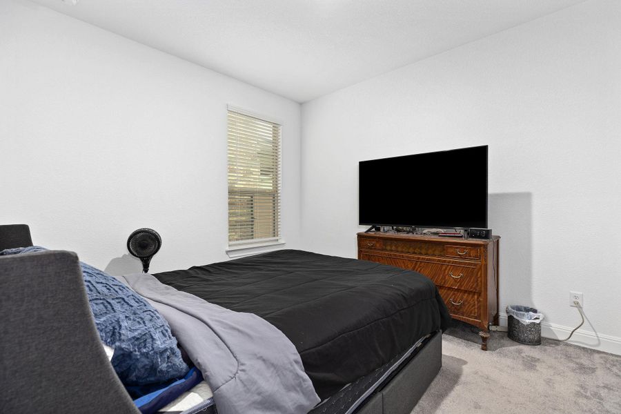 A well-appointed sleeping area features a bright window and soft carpeting.