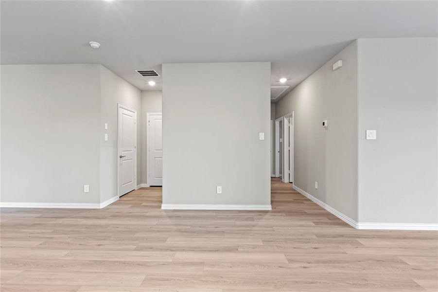 Unfurnished room featuring light wood-style flooring, recessed lighting, and a smoke detector Unfurnished room featuring light wood-style flooring, recessed lighting, and a smoke detector