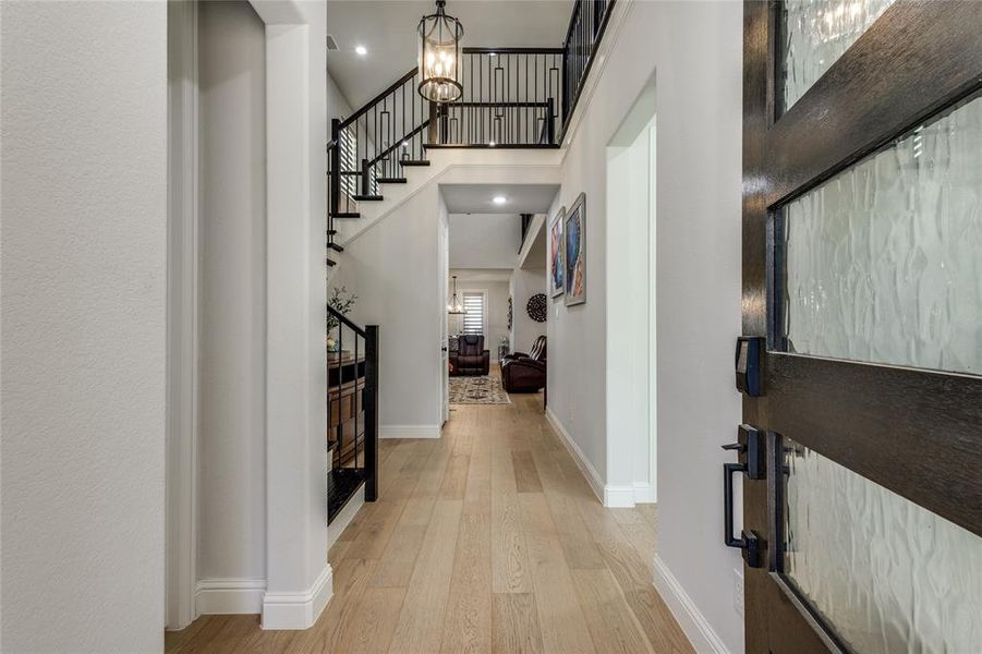 Entryway featuring light wood-type flooring, a high ceiling, and recessed lighting