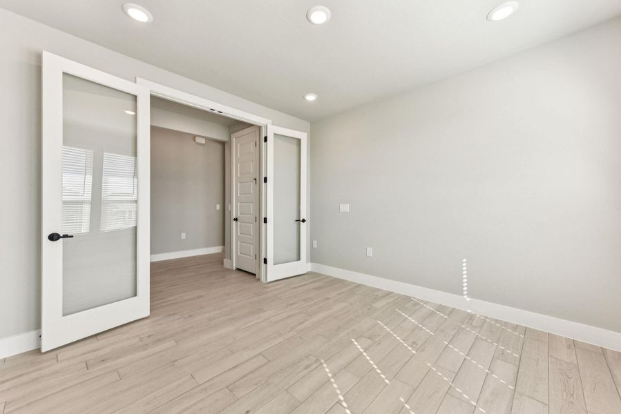 Unfurnished bedroom with light wood finished floors, recessed lighting, and french doors