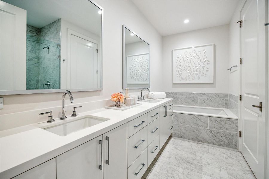 Primary bathroom with dual sinks, soaking tub, glass-framed walk-in shower with seat, private water closet, linen closet and a large walk-in dressing area. Photos are of a similar unit with the same floor plan Primary bathroom with dual sinks, soaking tub, glass-framed walk-in shower with seat, private water closet, linen closet and a large walk-in dressing area. Photos are of a similar unit with the same floor plan