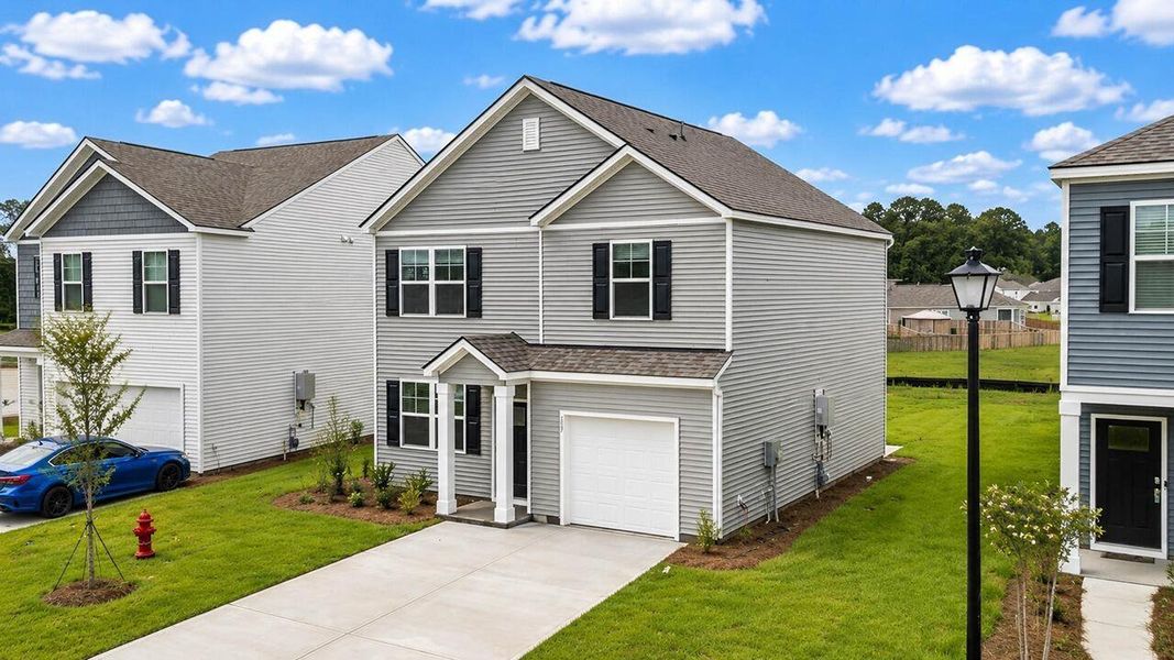 Front exterior of a new home in Pine Hills at Cane Bay, Summerville, SC, highlighting curb appeal (Image 1). Front exterior of a new home in Pine Hills at Cane Bay, Summerville, SC, highlighting curb appeal (Image 1).