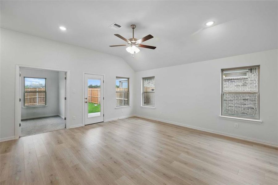 Spare room featuring a ceiling fan, vaulted ceiling, light wood-type flooring, and recessed lighting