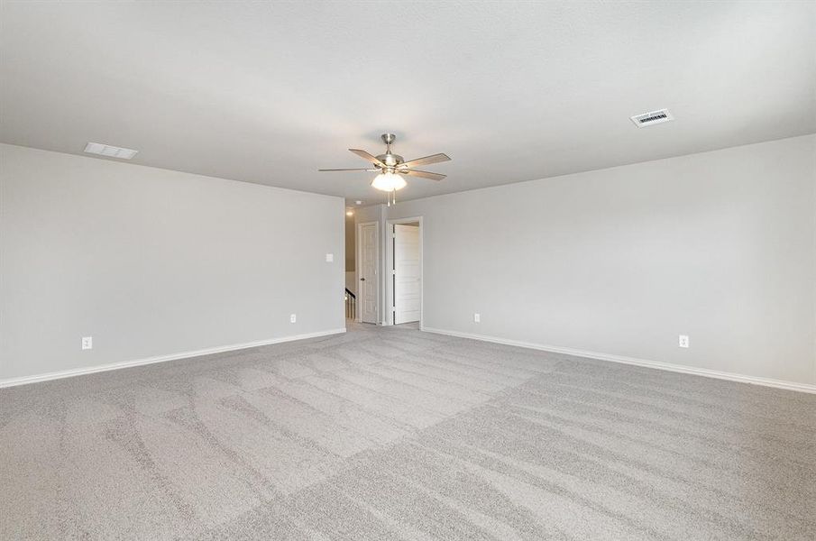 Carpeted spare room featuring ceiling fan