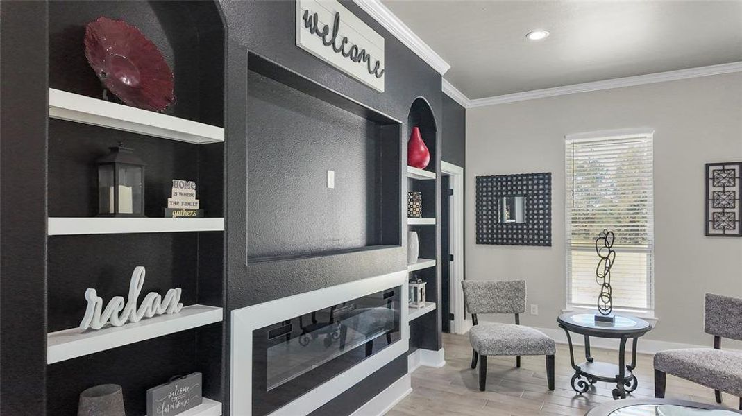 Living area with crown molding, light wood-type flooring, built in features, and recessed lighting