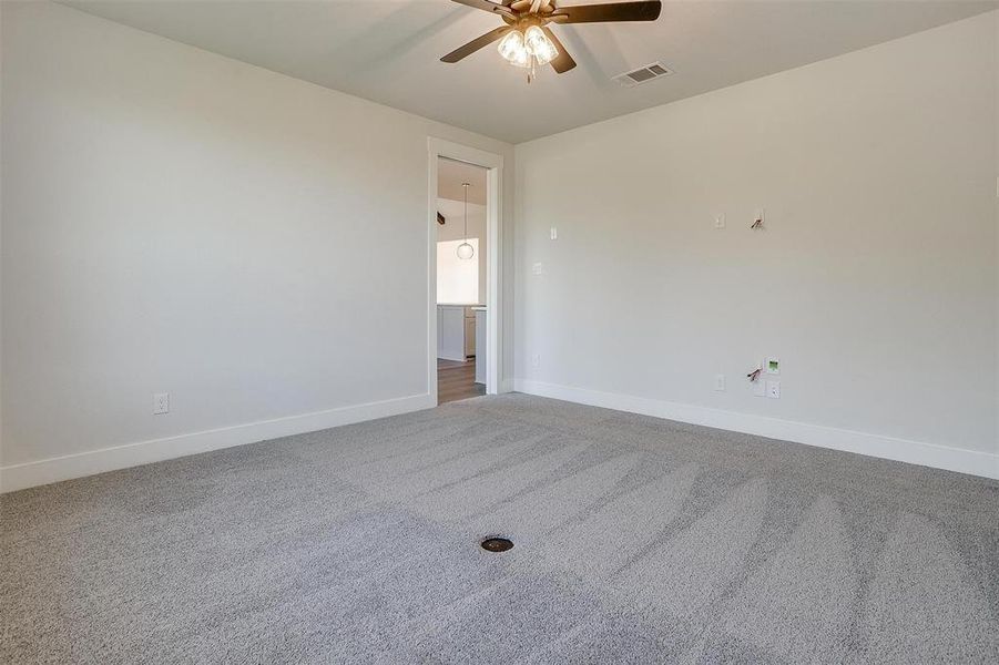 Empty room with carpet floors and ceiling fan