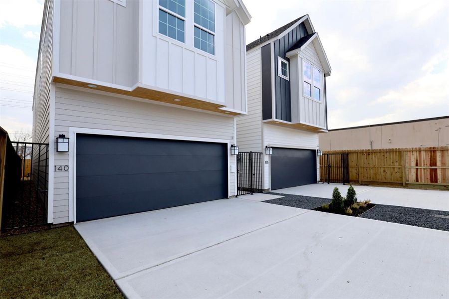Wide, private driveway framed by 7 FT cedar fencing.Low-Maintenance Landscaping, grass and clean gravel paths blended with plants.