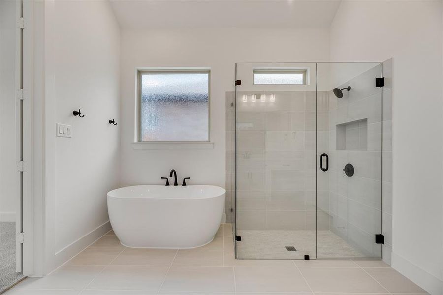 Bathroom with a shower stall, a freestanding tub, and tile patterned flooring Bathroom with a shower stall, a freestanding tub, and tile patterned flooring