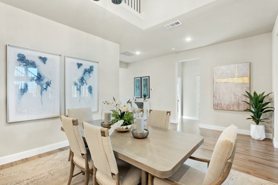 Formal dining room with wood table, six chairs, high ceilings, and abstract wall art Formal dining room with wood table, six chairs, high ceilings, and abstract wall art