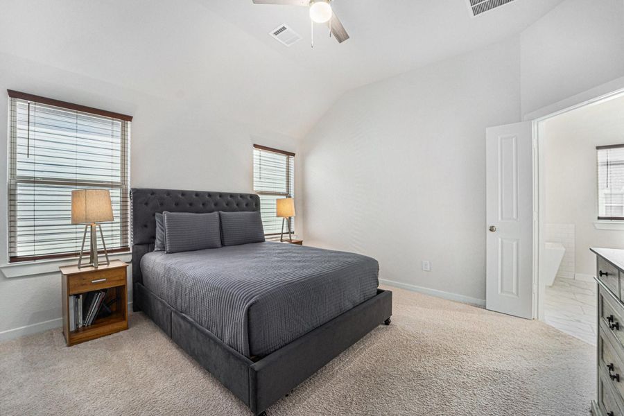 Spacious primary suite with natural light and plush carpet.