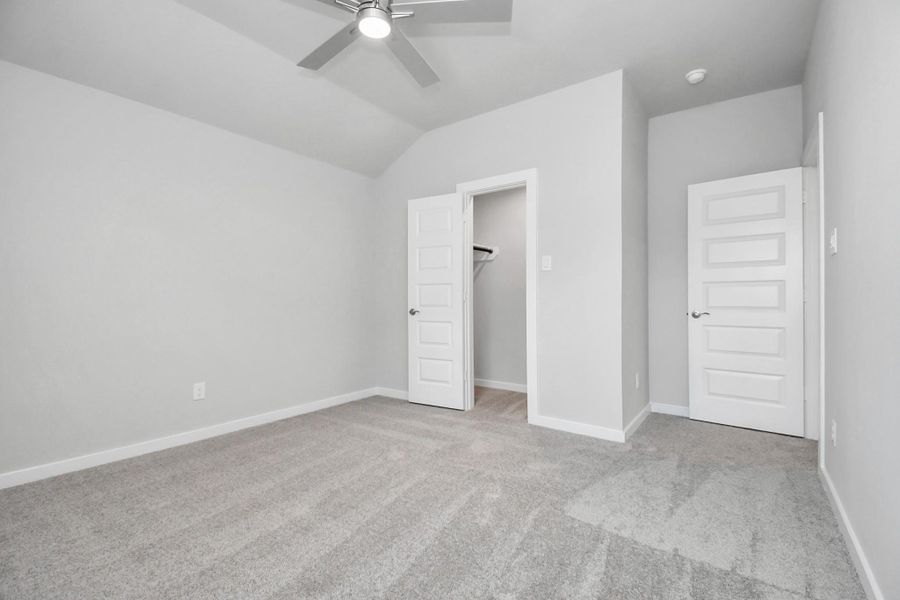 Secondary bedroom features plush carpeting, large windows that let in plenty of natural light, bright paint, and spacious closets. Sample photo of completed home with similar floor plan. Actual colors and selections may vary.
