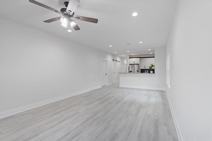 Unfurnished living room featuring light hardwood / wood-style floors and ceiling fan