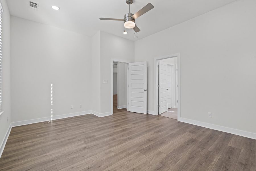 Unfurnished bedroom with ceiling fan, light wood finished floors, recessed lighting, and a high ceiling