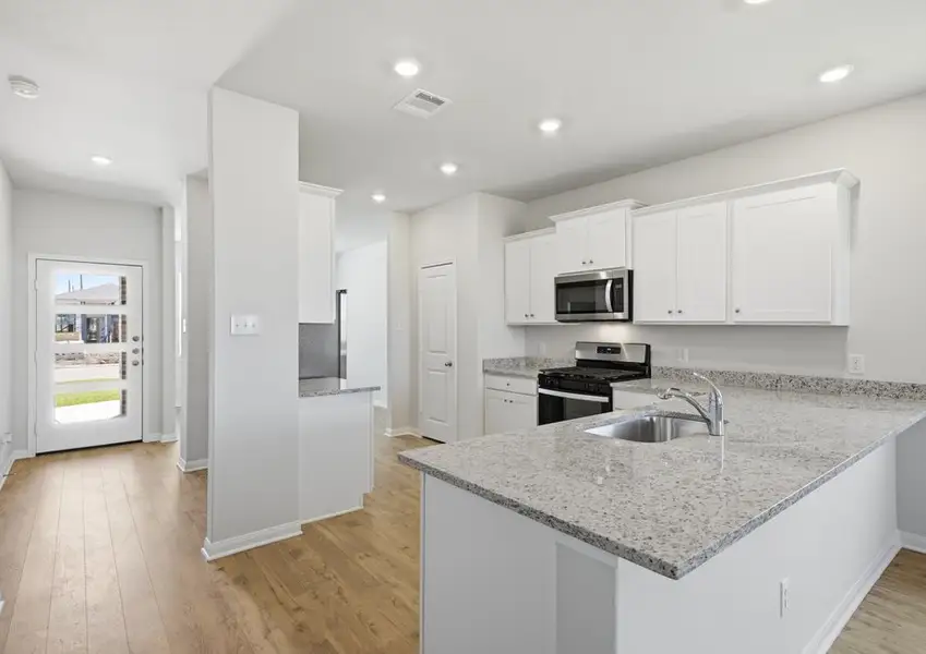 Kitchen island and stainless range with granite countertops in Montgomery floor plan