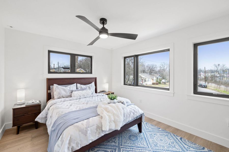 Bedroom with baseboards, light wood-type flooring, and ceiling fan