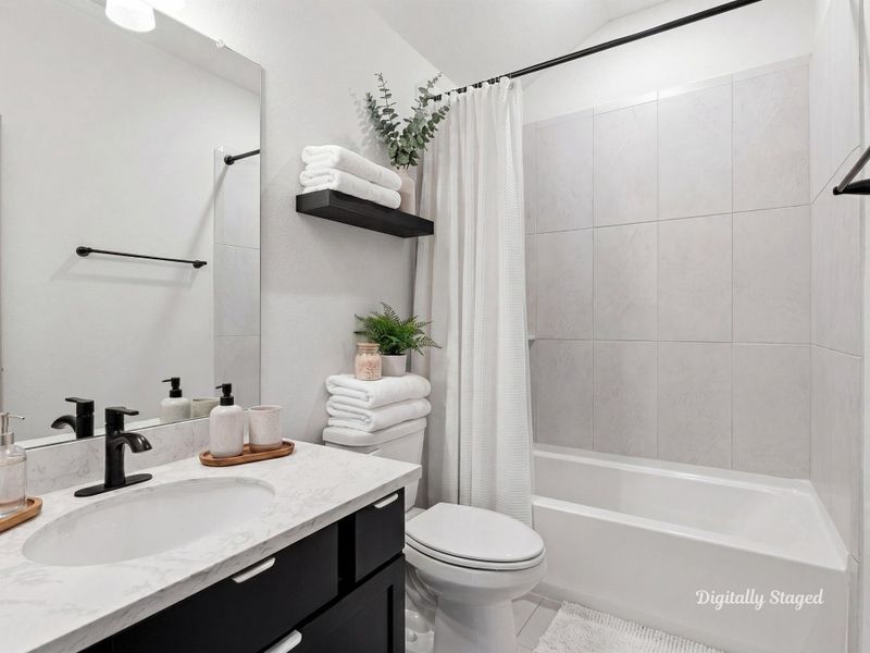 Full bath with a vanity and stone-look countertop set beneath a vaulted ceiling. A tub-and-shower combination with tile surround and a floating shelf add both style and storage. This photo has been digitally staged to illustrate the possibilities of the home's aesthetic and potential design. Some furnishings and décor shown are for visual inspiration.