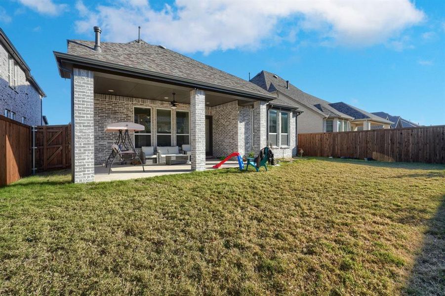 Back of house featuring a lawn, ceiling fan, an outdoor living space, and a patio