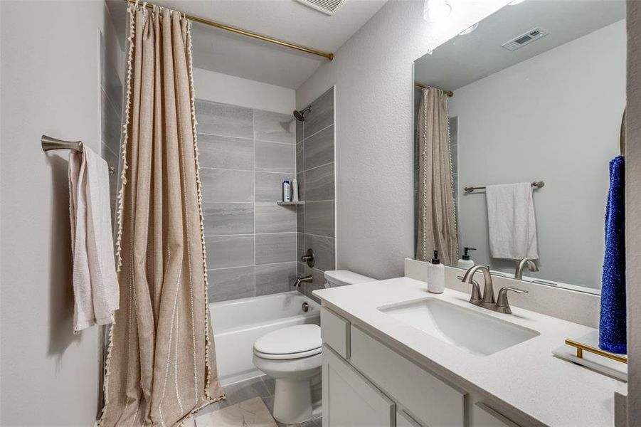 Full bathroom with shower / bath combination with curtain, toilet, and vanity