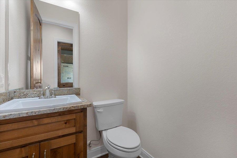 Half bathroom featuring baseboards and vanity