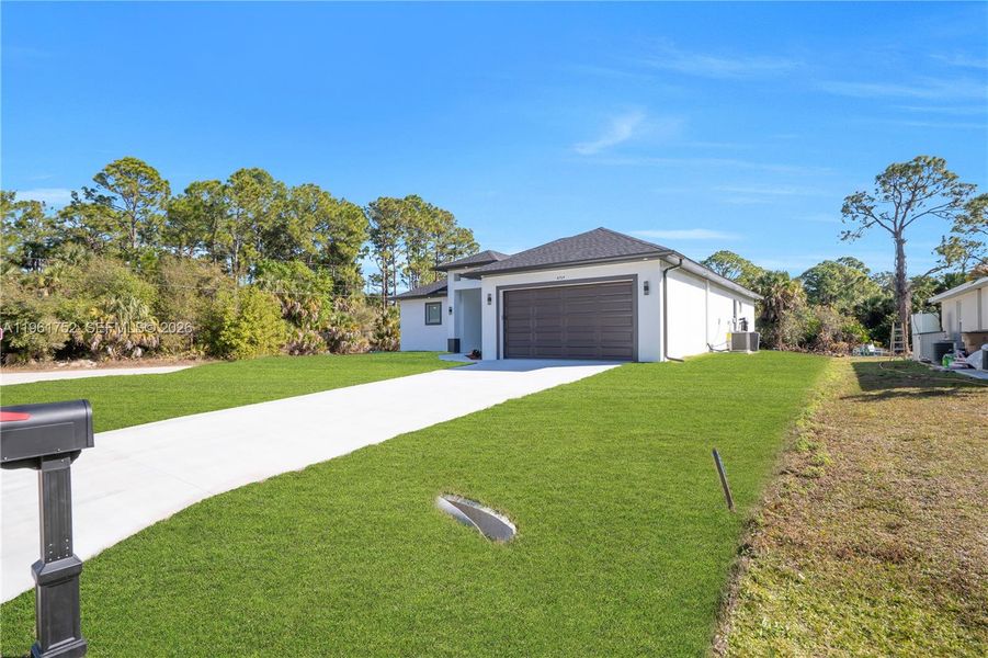 Front exterior of a new home in , Lehigh Acres, FL, highlighting curb appeal (Image 24).