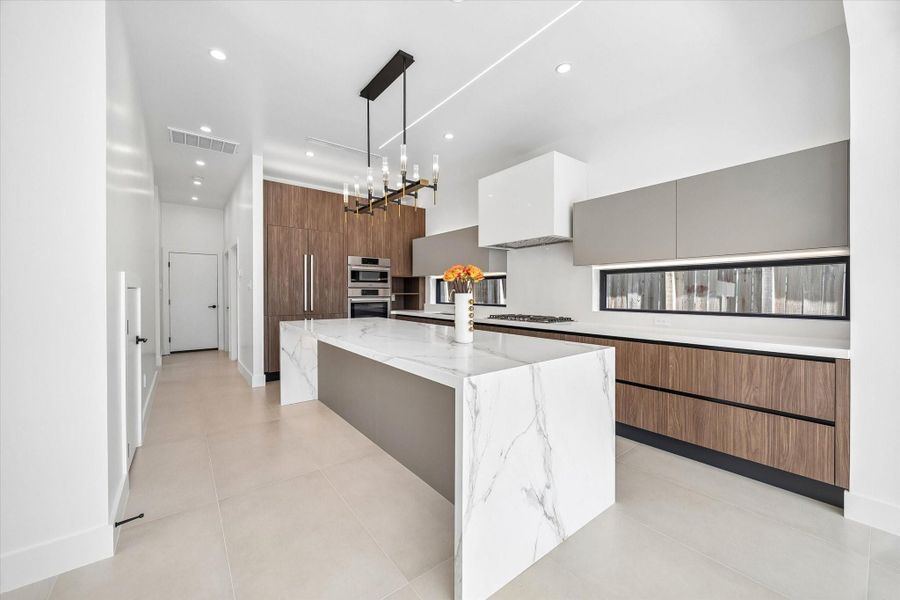 Chef’s kitchen with Bosch appliances, a paneled Dacor refrigerator, quartzite island, gas cooktop, double-ovens and beverage center. Chef’s kitchen with Bosch appliances, a paneled Dacor refrigerator, quartzite island, gas cooktop, double-ovens and beverage center.