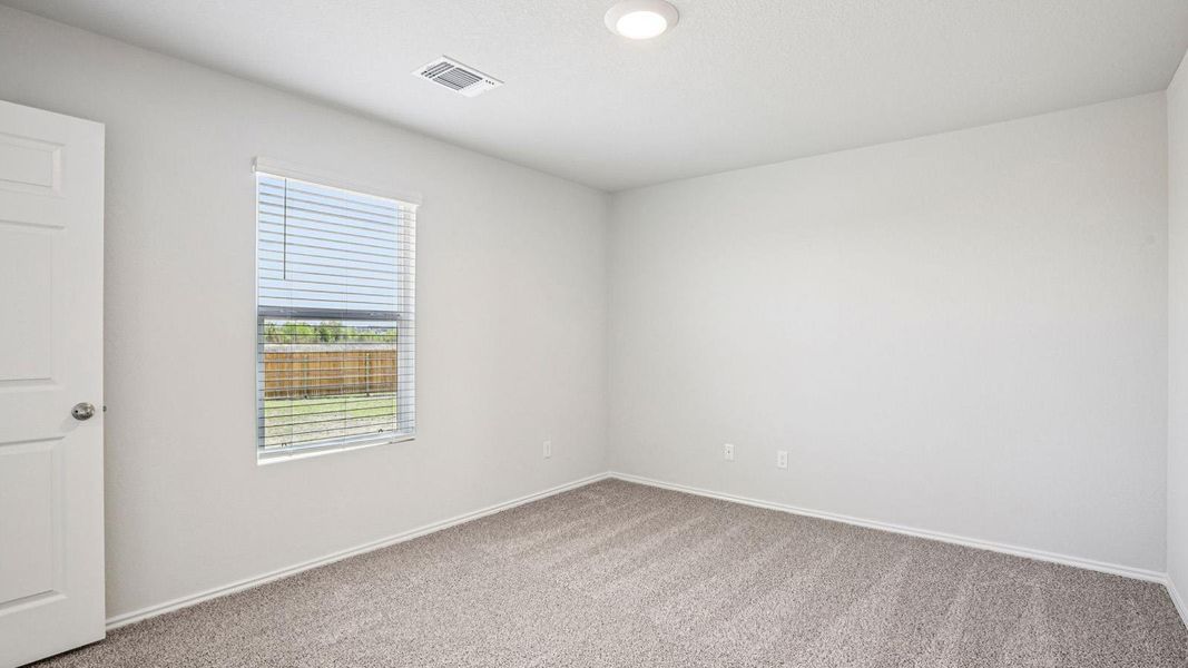 Neutral tone wall paint, textured carpeting, window with blinds, recessed ceiling light, and white paneled door Neutral tone wall paint, textured carpeting, window with blinds, recessed ceiling light, and white paneled door