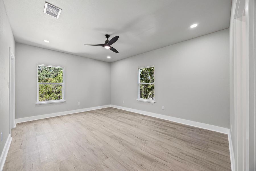 Bedroom featuring light wood-type flooring, recessed lighting, and a ceiling fan Bedroom featuring light wood-type flooring, recessed lighting, and a ceiling fan