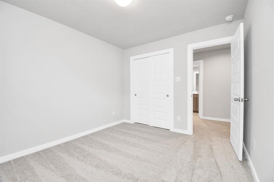 Secondary bedroom features plush carpeting, large windows that let in plenty of natural light, bright paint, and spacious closets. Sample photo of completed home with similar floor plan. Actual colors and selections may vary.