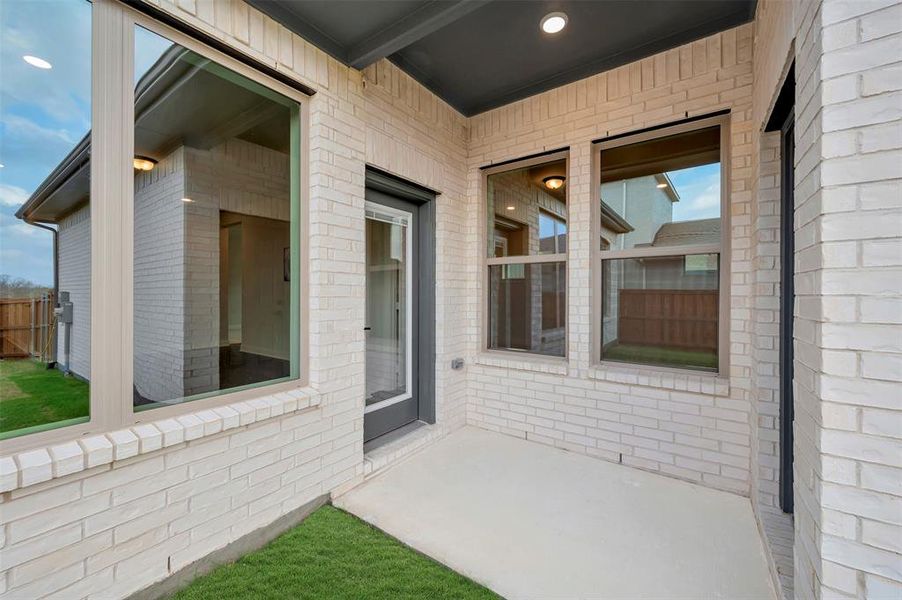 Property entrance featuring brick siding and a patio