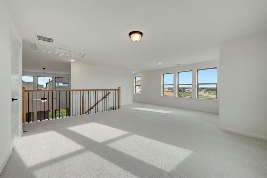 Empty room with carpet floors, healthy amount of natural light, and recessed lighting