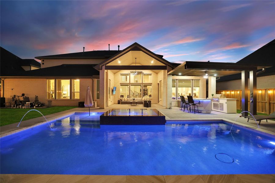 Experience the backyard oasis after sunset, where elegant landscape lighting, sparkling water features, and the beautifully illuminated pool create a breathtaking setting for relaxing or entertaining.