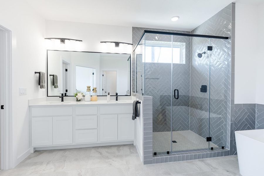Full bath featuring a freestanding bath, double vanity, and a stall shower