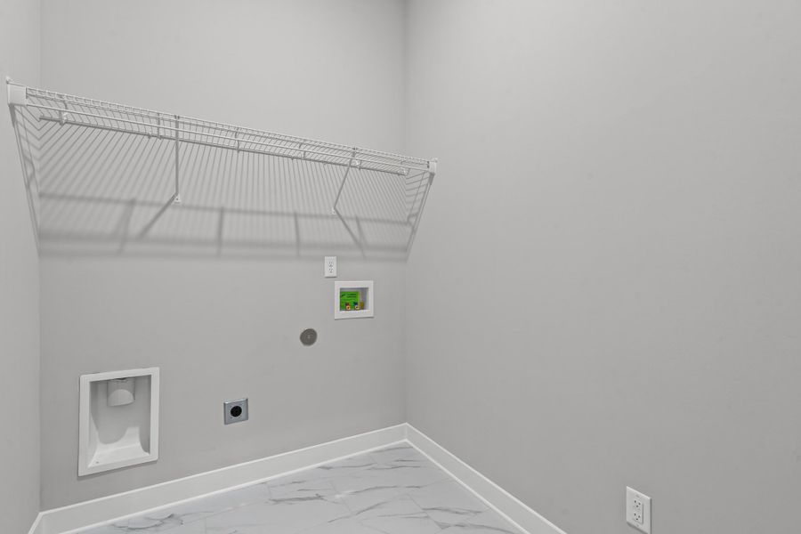 Washroom with hookup for a washing machine, light marble finish flooring, and hookup for an electric dryer