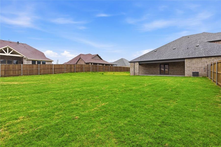Expansive green lawn with a wood privacy fence Expansive green lawn with a wood privacy fence