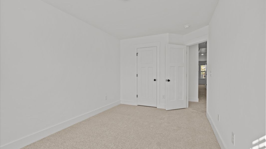 Superior comfort in a secondary bedroom with plush carpet and an oversized walk-in closet