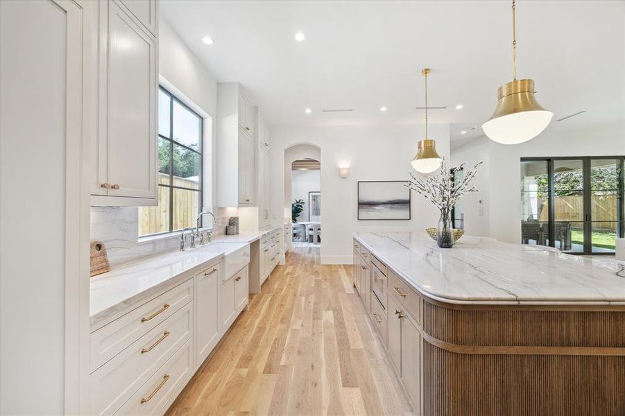 The kitchen offers a farm sink, dishwasher (to be paneled), and Brizo plumbing fixtures. Note the kitchen cabinetry extended to the ceiling.