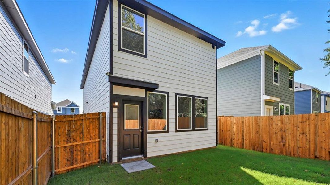 Rear view of house featuring a fenced backyard