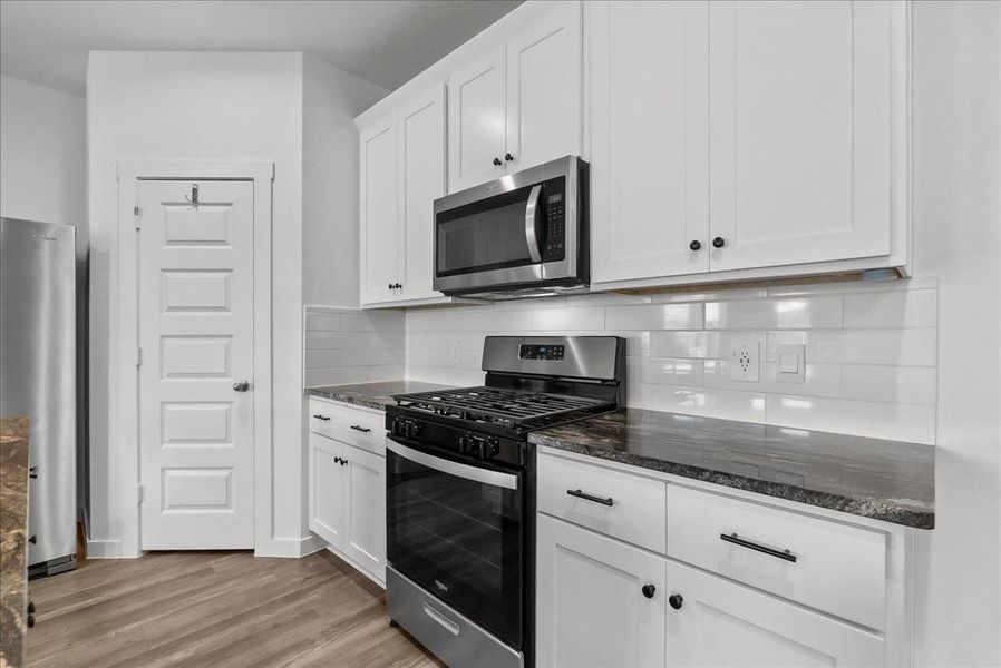 Chef’s eat-in island kitchen boasts stainless steel appliances, 42” cabinets with crown molding, lengthy countertops, breakfast bar seating, and a spacious pantry.