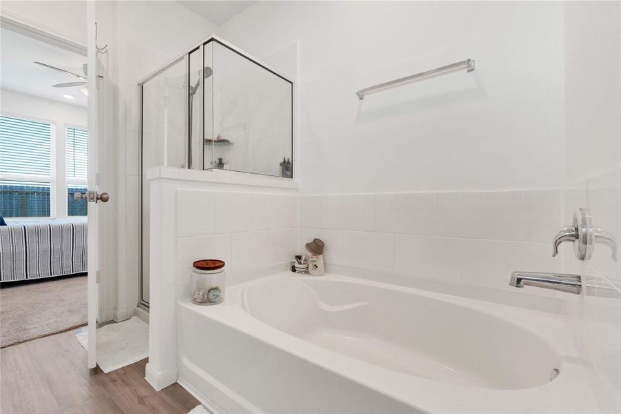 Enjoy a touch of luxury in the private en-suite bathroom, featuring dual vanities, a soaking tub, and a separate walk-in shower—your personal space to unwind and rejuvenate.